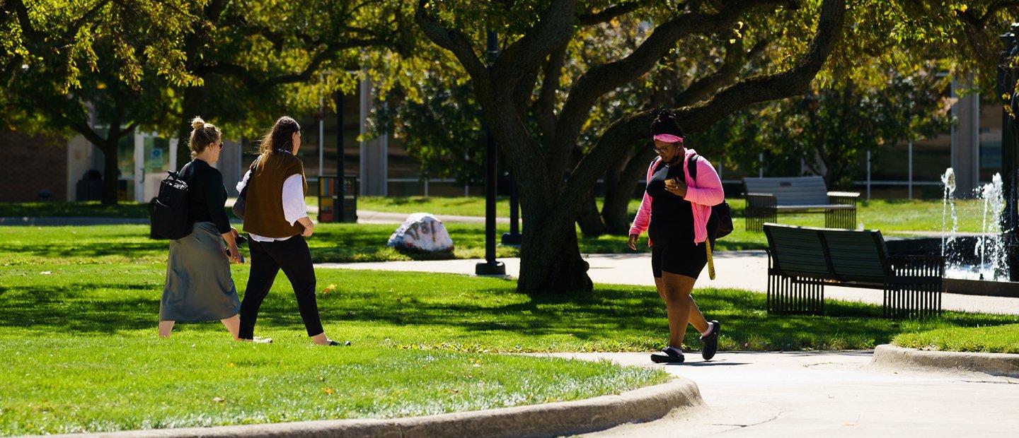 Students walking in front of a fountain on Oakland University's campus in Summer.